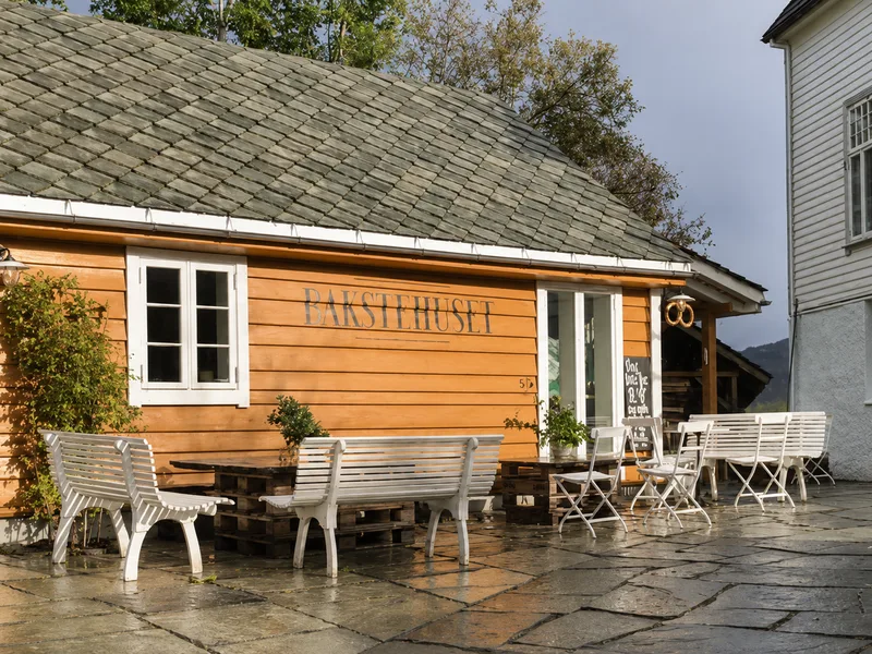 The ochre timber bakery at Ask with benches in the yard