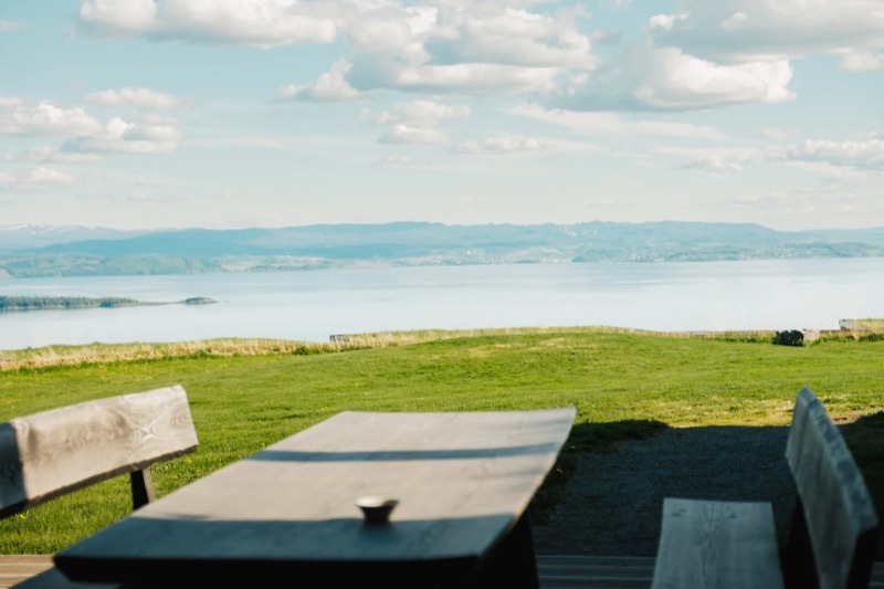 A wooden table and benches facing the Trondheimsfjord